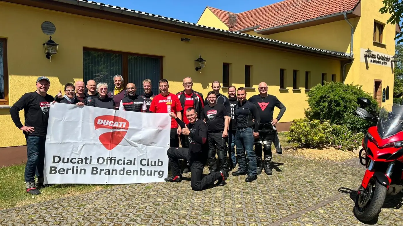 Gruppenfoto mit Banner und Ducatis bei der ersten Ausfahrt