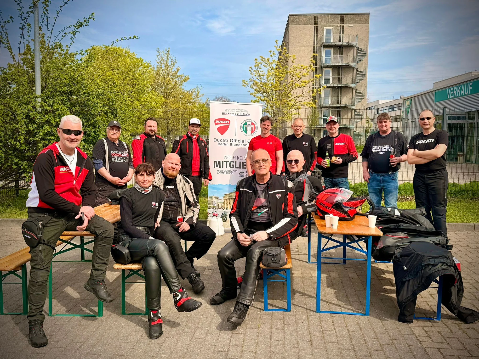 Mitglieder des D.O.C. Berlin Brandenburg beim Saisonstart 2026 bei Riller & Schnauck, dahinter das Clubbanner